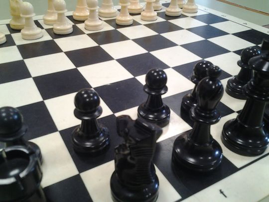 tablero de ajedrez en blanco y negro con piezas negras en primer plano